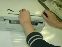 使用者可以将切刀放在手柄上，修剪掉袋子中多余的部分。